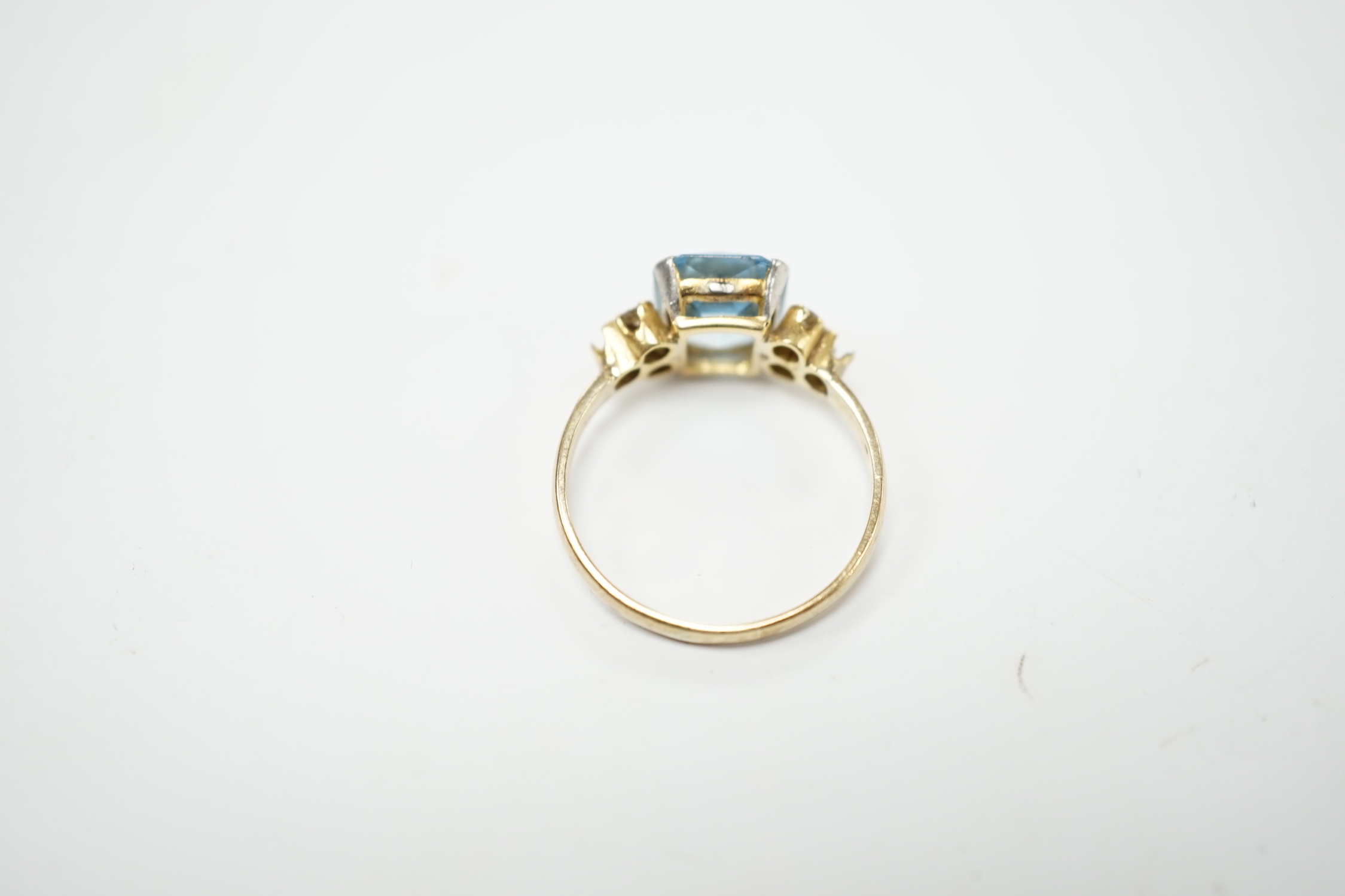 A yellow metal, single stone aquamarine and four stone diamond chip set dress ring, size M, gross weight 2.2 grams.